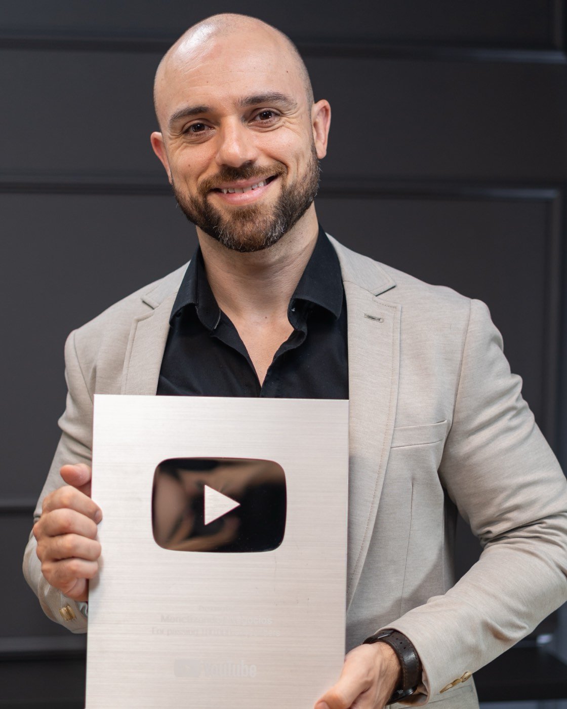 Everton Lourenço segurando a placa de 100 mil inscritos do YouTube
